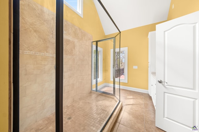 bathroom with vaulted ceiling, an enclosed shower, vanity, and tile patterned flooring