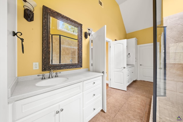 bathroom featuring vanity, vaulted ceiling, tile patterned floors, and walk in shower