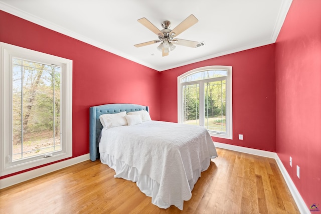 bedroom featuring crown molding, light hardwood / wood-style flooring, and ceiling fan