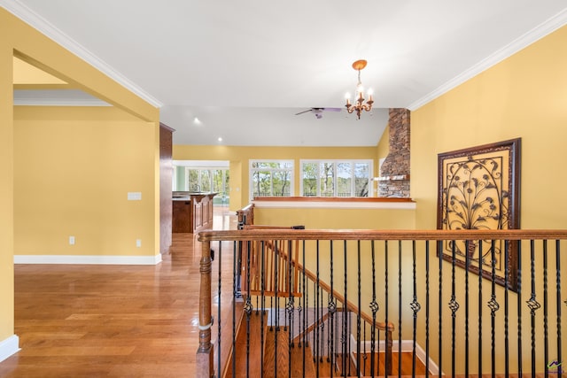 hall with lofted ceiling, wood-type flooring, a chandelier, and crown molding