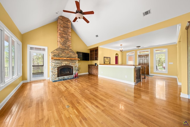 unfurnished living room with high vaulted ceiling, ceiling fan, a fireplace, and light hardwood / wood-style flooring