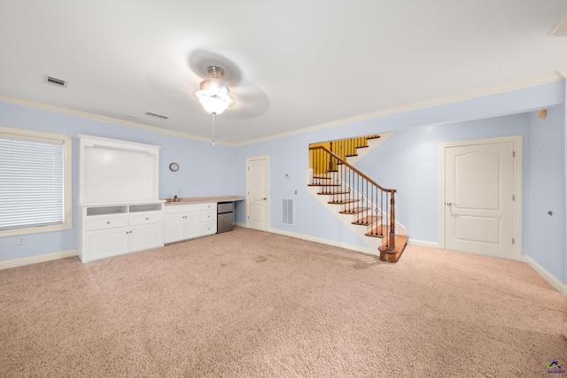 interior space with crown molding, ceiling fan, and light colored carpet