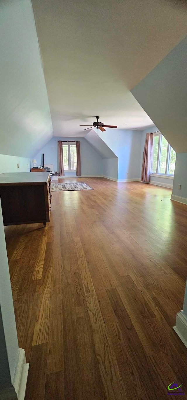 additional living space with dark wood-type flooring, ceiling fan, a textured ceiling, and vaulted ceiling