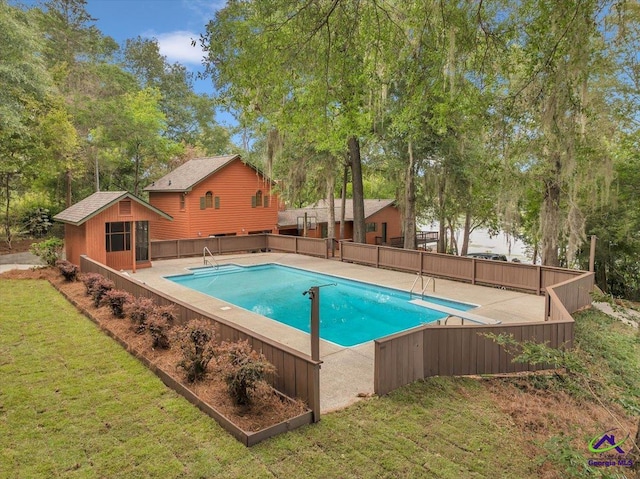 view of swimming pool with a yard, an outbuilding, and a diving board