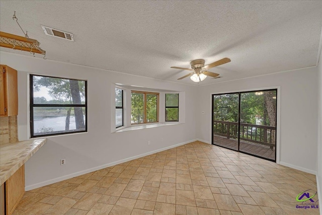 unfurnished room featuring a textured ceiling and ceiling fan