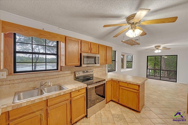 kitchen featuring a textured ceiling, backsplash, stainless steel appliances, kitchen peninsula, and ceiling fan