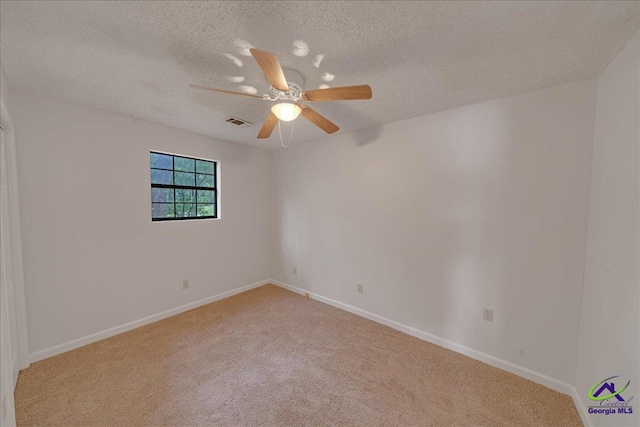 unfurnished room featuring ceiling fan, light carpet, and a textured ceiling