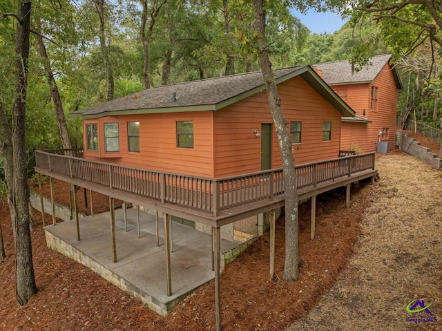 rear view of property featuring a wooden deck and a patio area