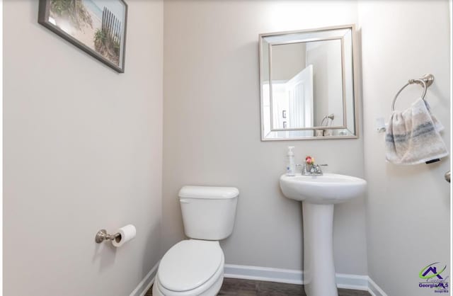 bathroom with wood-type flooring and toilet