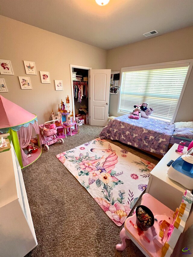 carpeted bedroom featuring a closet and a walk in closet