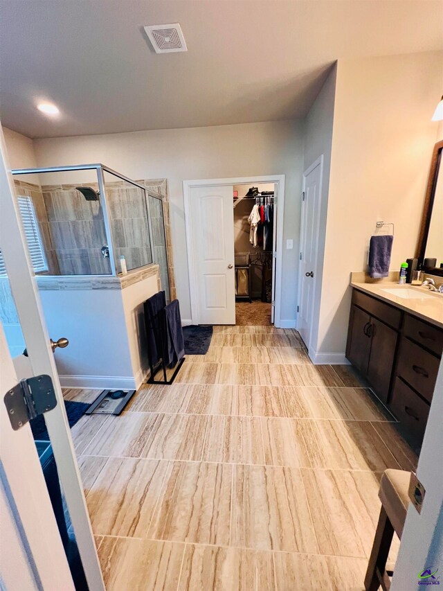 bathroom featuring vanity and a shower with shower door