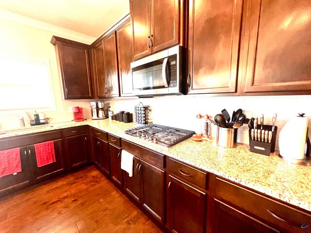 kitchen featuring light stone counters, sink, appliances with stainless steel finishes, and dark wood-type flooring