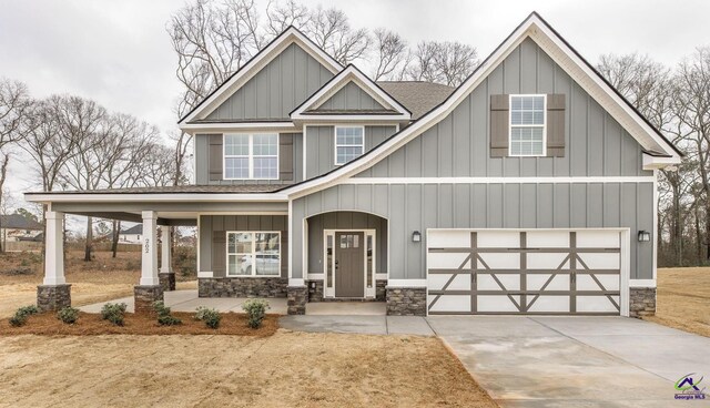 202 Bella Notte Cir, Warner Robins, GA 31088 - craftsman-style home with an attached garage, board and batten siding, driveway, a porch, and stone siding