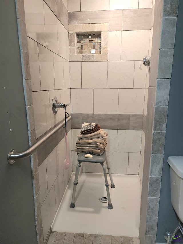 bathroom featuring toilet and tiled shower