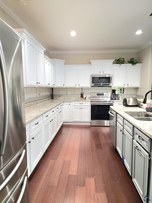 203 Lattice Bnd, Bonaire, GA 31005 - kitchen featuring stainless steel appliances, a sink, ornamental molding, dark wood-type flooring, and white cabinetry