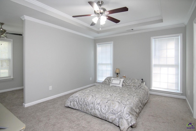 carpeted bedroom featuring ornamental molding, a tray ceiling, and ceiling fan