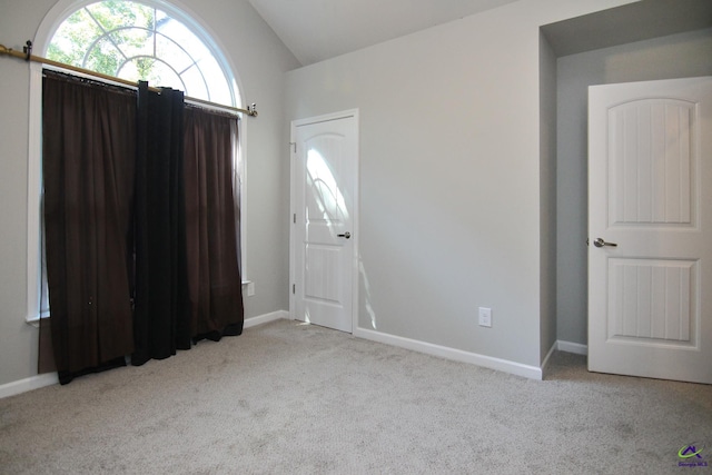 interior space with lofted ceiling and light carpet