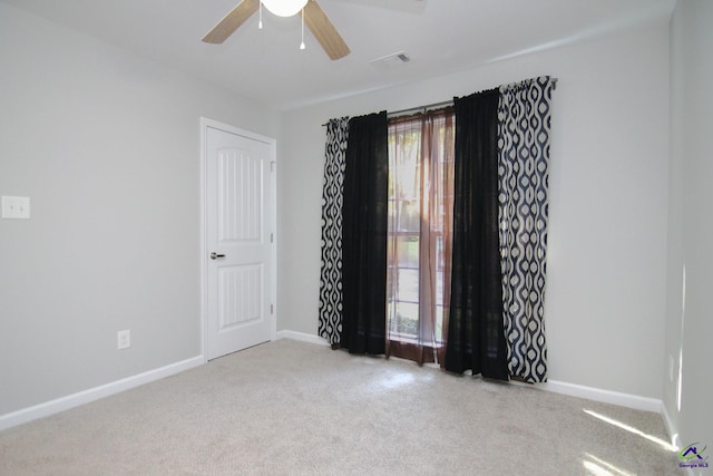 spare room featuring light carpet and ceiling fan