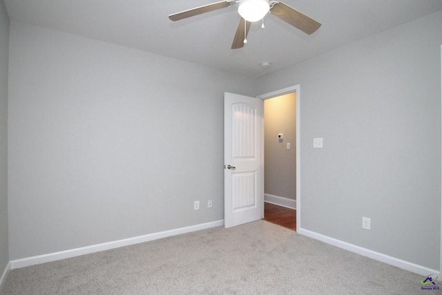 carpeted spare room featuring ceiling fan