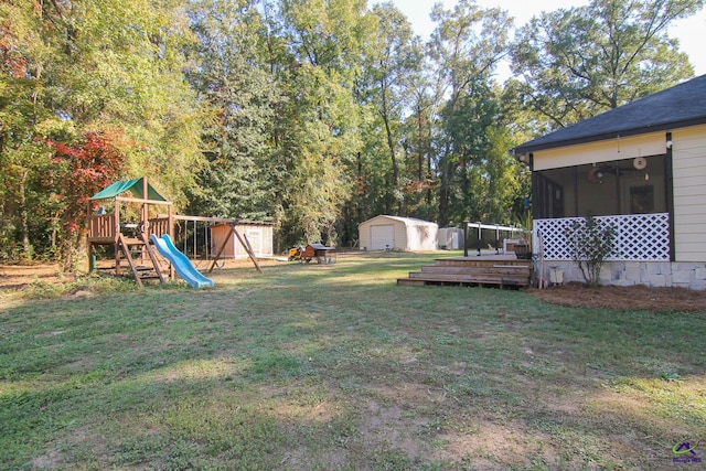 view of yard featuring a shed, a playground, and a wooden deck