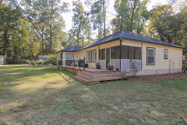 back of property featuring a deck, a sunroom, and a lawn