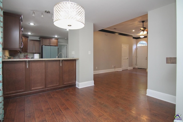 kitchen with kitchen peninsula, dark wood-type flooring, pendant lighting, and refrigerator