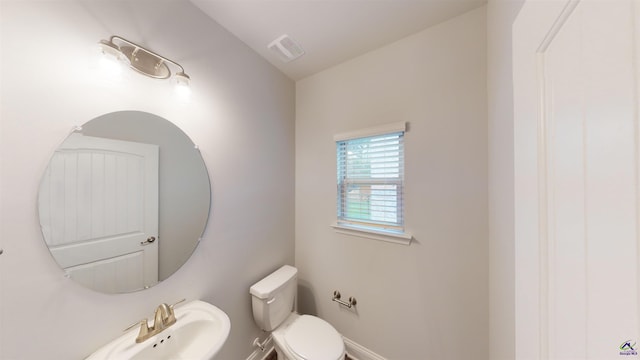 bathroom featuring vaulted ceiling, sink, and toilet