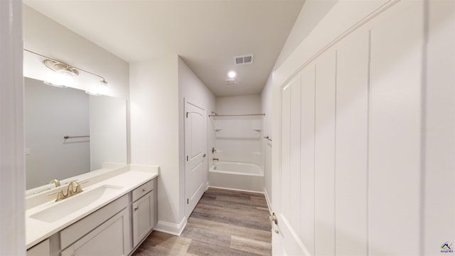 bathroom with wood-type flooring,  shower combination, and vanity