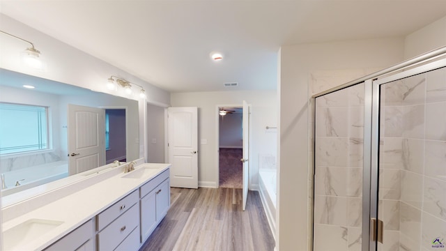 bathroom with wood-type flooring, vanity, and separate shower and tub