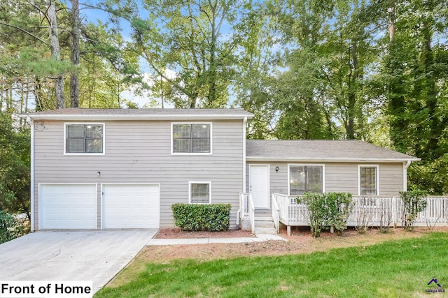 tri-level home featuring a garage and a front lawn