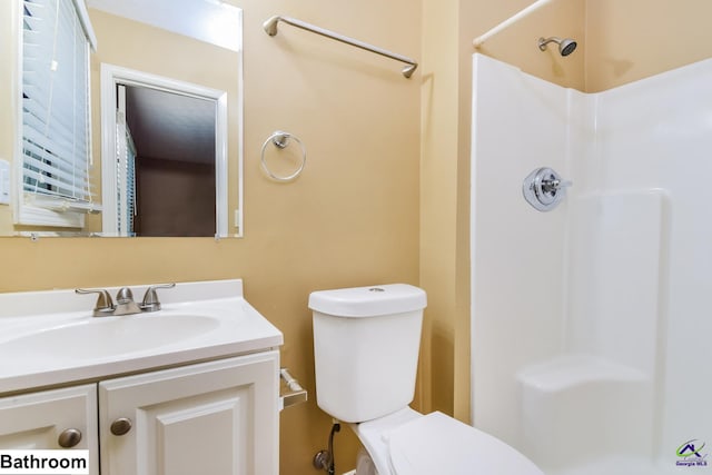 bathroom with a shower, vanity, and toilet