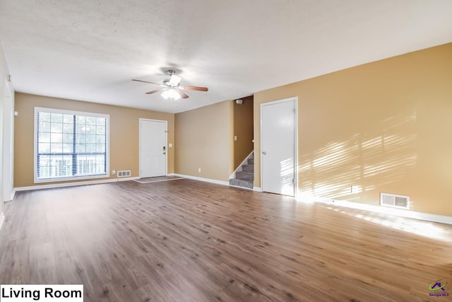 spare room with a textured ceiling, wood-type flooring, and ceiling fan