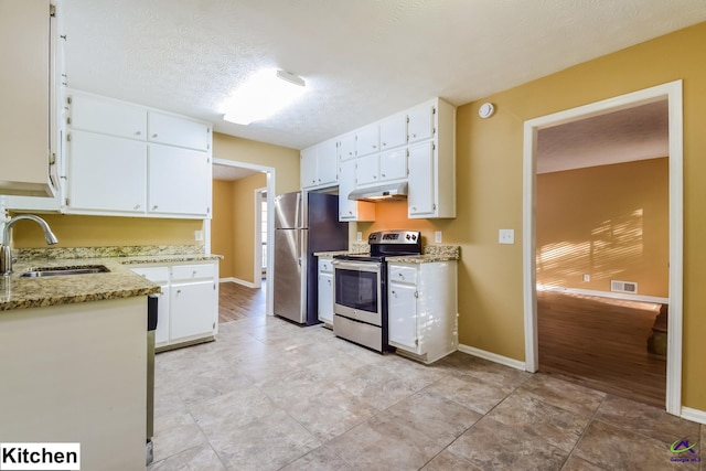 kitchen with white cabinets, sink, a textured ceiling, appliances with stainless steel finishes, and light stone countertops