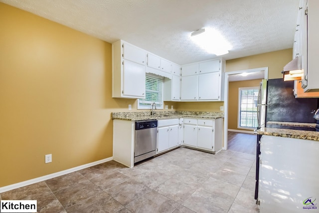 kitchen featuring a textured ceiling, light stone countertops, white cabinetry, and stainless steel dishwasher