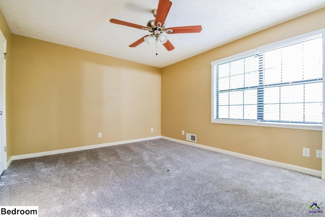 carpeted spare room featuring ceiling fan