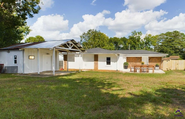 back of property with a yard and a patio