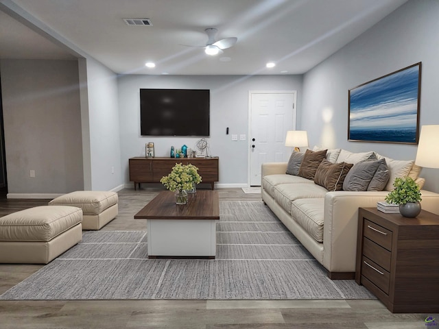 living room with light hardwood / wood-style flooring and ceiling fan