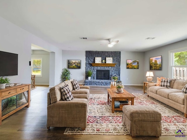 living room with a stone fireplace, hardwood / wood-style floors, and ceiling fan