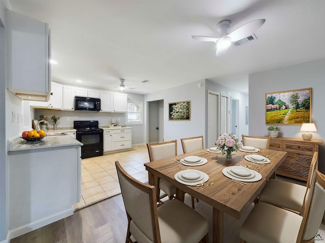 tiled dining space featuring ceiling fan and sink