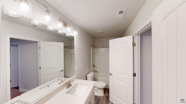 full bathroom with hardwood / wood-style floors, shower / tub combination, vanity, and toilet