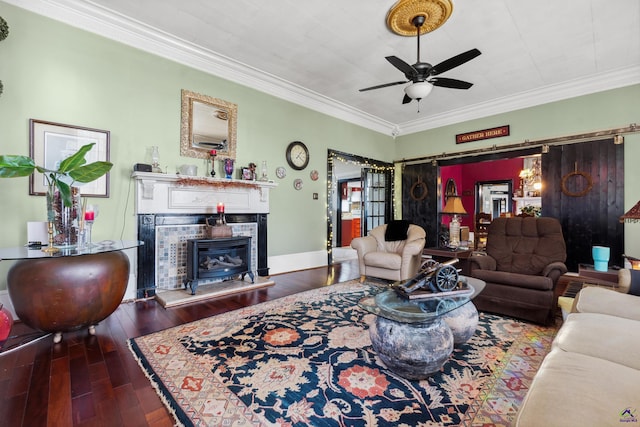 living room featuring a tile fireplace, crown molding, dark hardwood / wood-style flooring, and ceiling fan