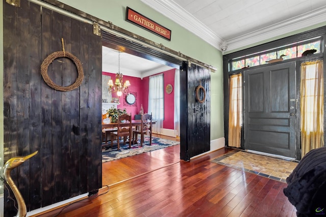 entryway featuring a barn door, crown molding, hardwood / wood-style floors, and a chandelier