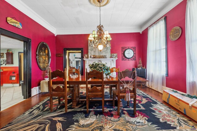 dining room with heating unit, crown molding, an inviting chandelier, and wood-type flooring