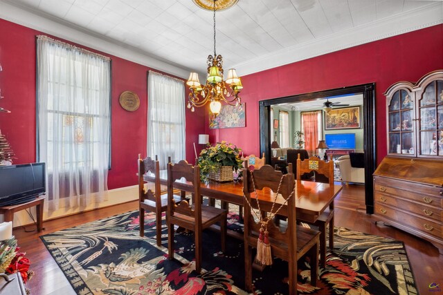 dining room with ceiling fan with notable chandelier, crown molding, and hardwood / wood-style floors