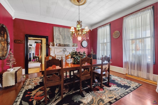 dining space featuring wood-type flooring, crown molding, and a chandelier