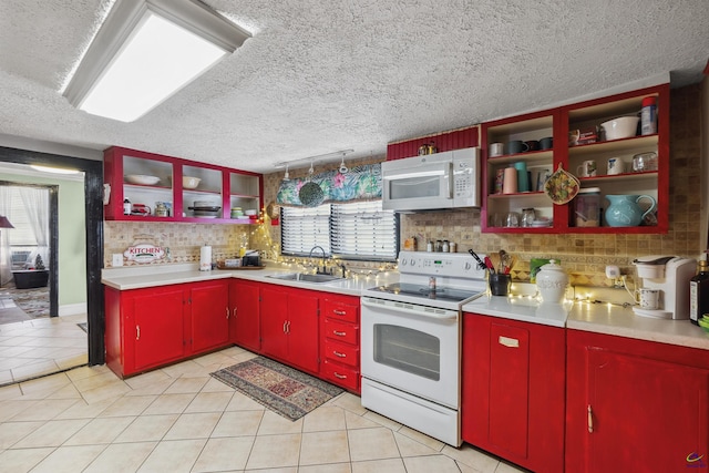 kitchen with light tile patterned floors, a textured ceiling, sink, and white appliances