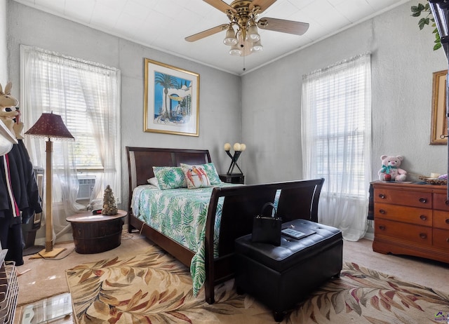 bedroom with crown molding, light carpet, and ceiling fan