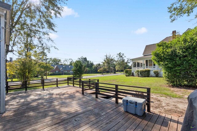 wooden deck featuring a lawn