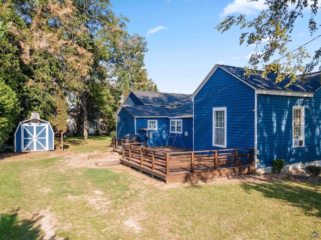 back of house with a shed, a deck, and a yard