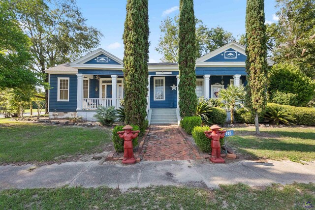 neoclassical home with a front yard and a porch